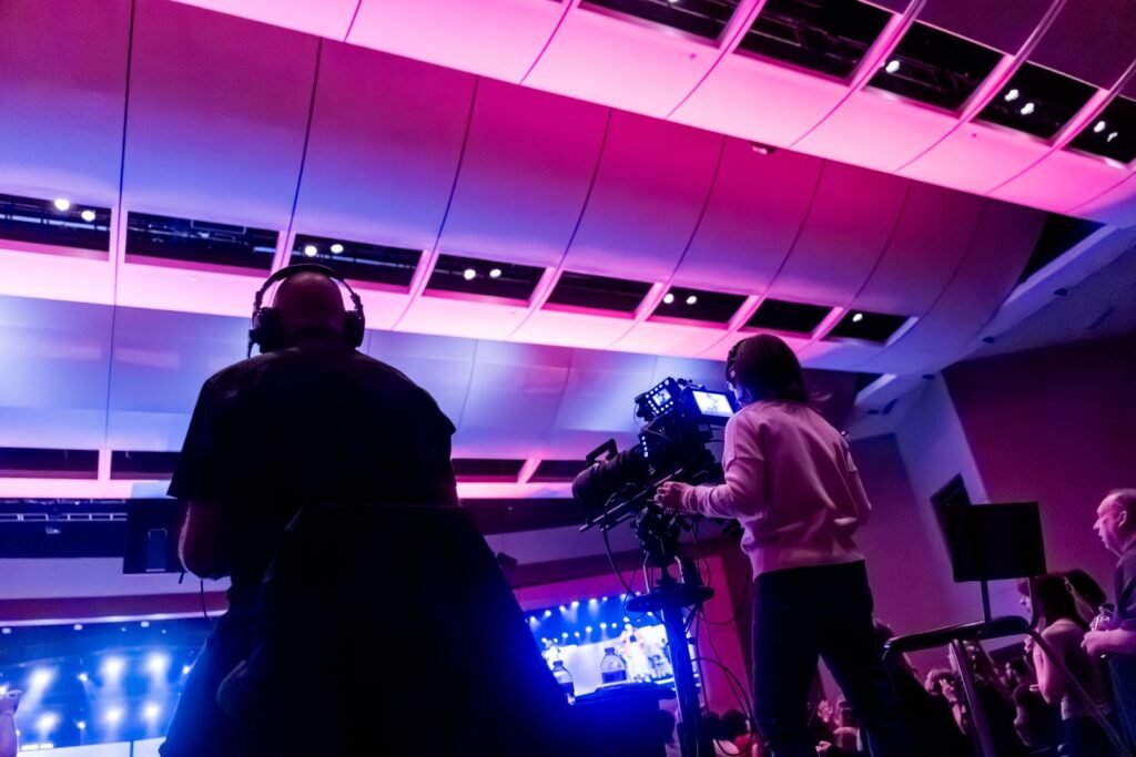 Equipo de cámaras profesionales cubriendo un evento en vivo con iluminación de escenario