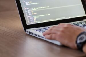 Desarrollador programando código HTML en un laptop