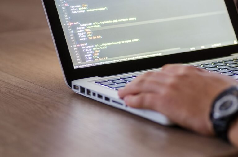 Desarrollador programando código HTML en un laptop