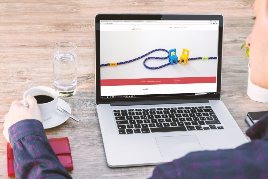 Escritorio de trabajo con laptop, café y vaso de agua